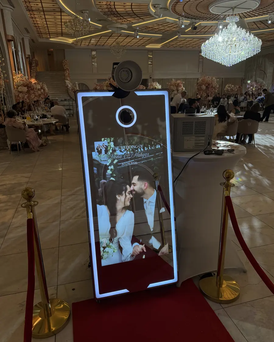 Mirror-photobooth met foto van het bruidspaar in een feestzaal met kroonluchters