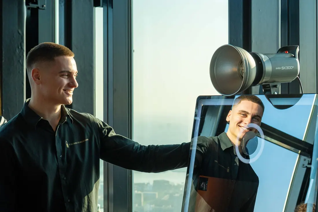 Begeleider bedient de mirror-photobooth met professionele camera