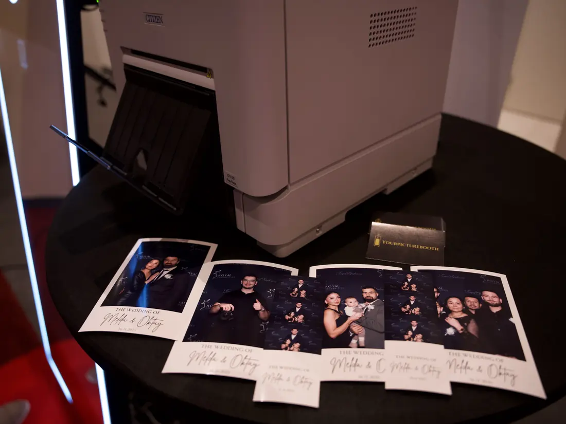 Geprinte fotostrips naast de printer van de photobooth