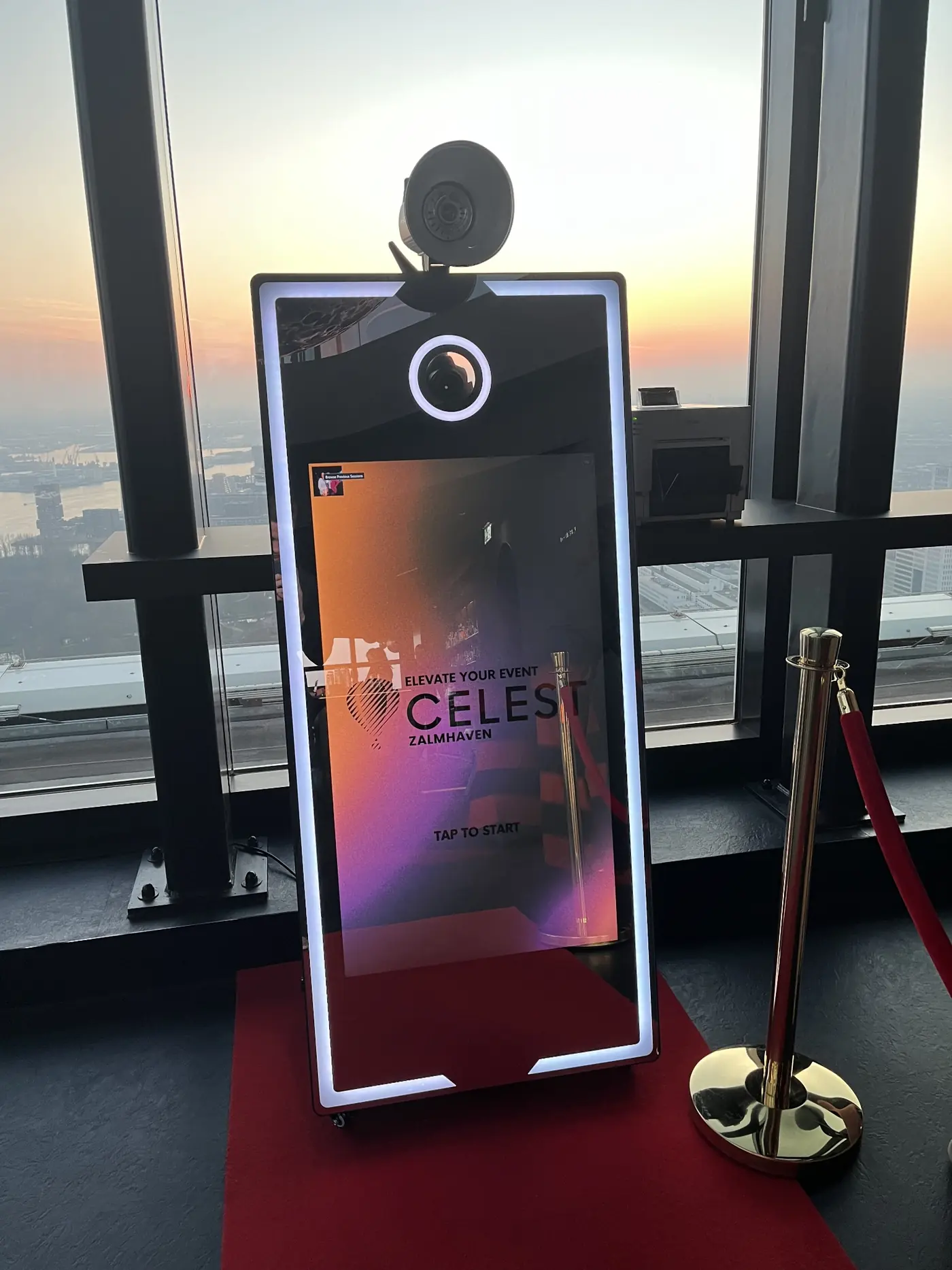 Mirror-photobooth voor een raam met uitzicht op de zonsondergang