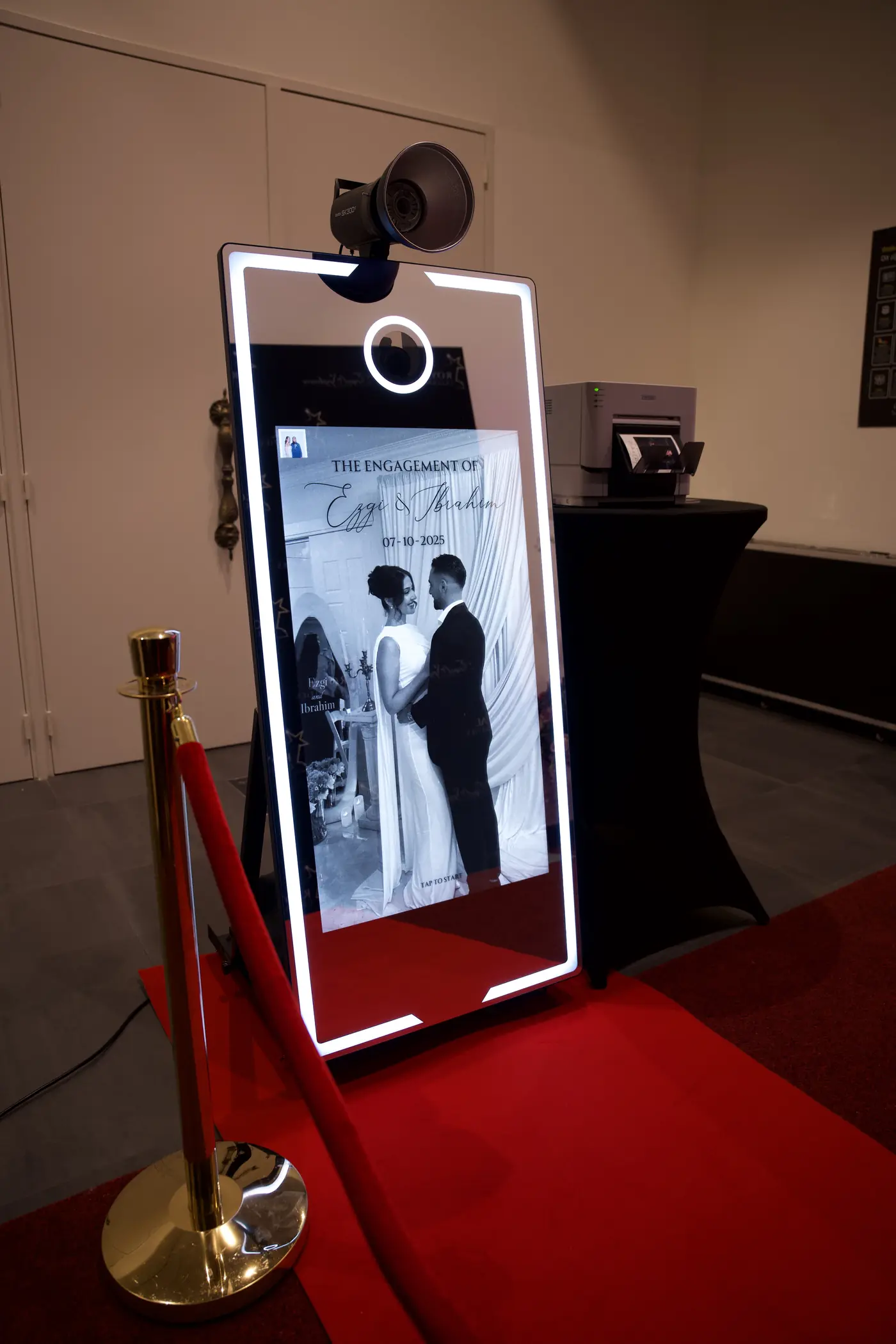 Mirror-photobooth met een foto van het bruidspaar op het startscherm, op de rode loper