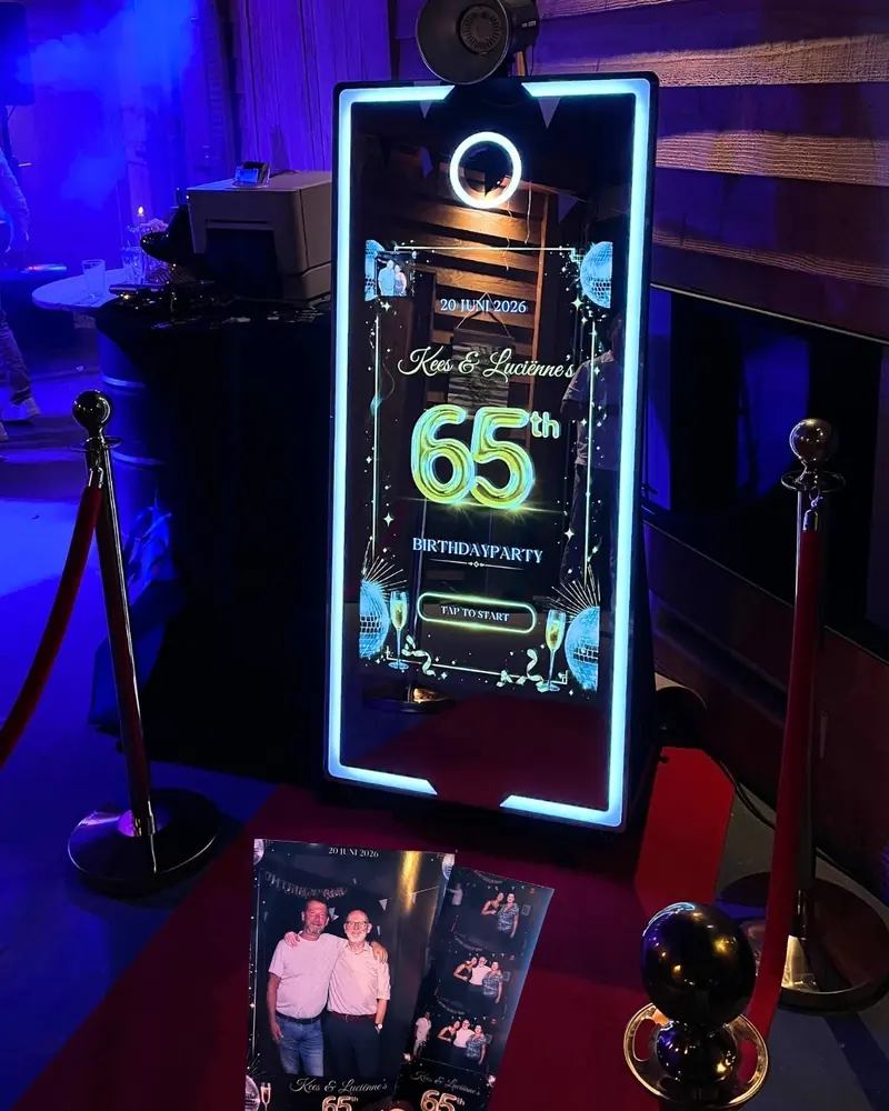 Spiegel photobooth met het startscherm van de 65e verjaardag van Kees en Luciënne, met geprinte fotostrips